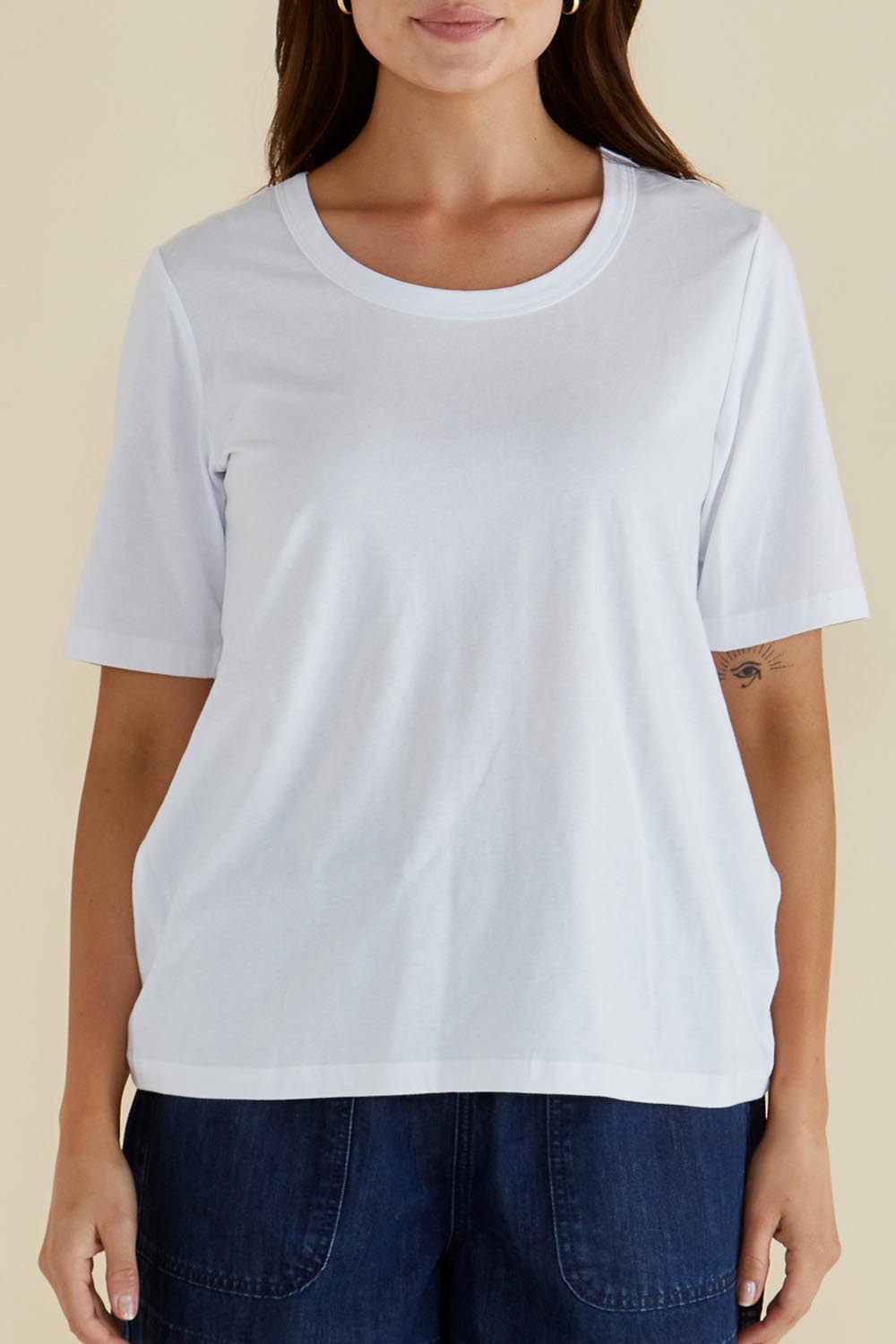 A model wearing the Riley Cotton Tee in colour White (White), from the front, cropped image