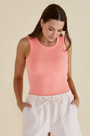 A model wearing the Francis Rib Tank in colour Peach (Pink), from the front, cropped image