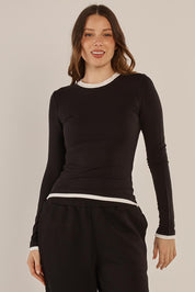 A model wearing the Cloud Tee in colour Black (Black), from the front, cropped image