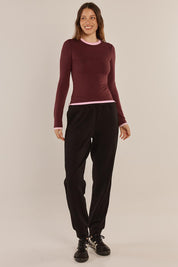 A model wearing the Cloud Tee in colour Burgandy (Red), from the front, showing the whole outfit