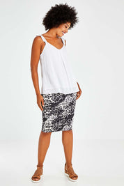 Model Olivia wearing size 8 of the Alicia Midi Skirt in colour Nala (Black), from the front, showing the whole outfit
