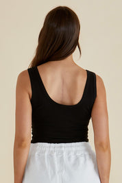 A model wearing the Emma Cotton Scoop Tank in colour Black (Black), from the back