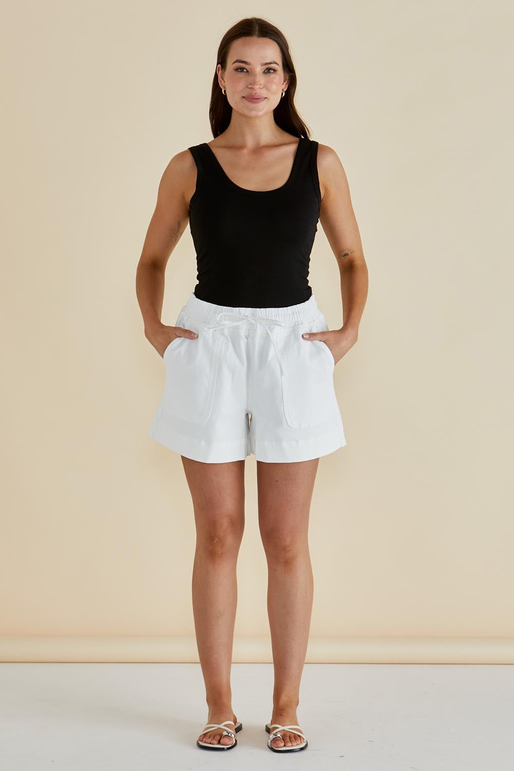 A model wearing the Emma Cotton Scoop Tank in colour Black (Black), from the front, showing the whole outfit