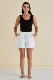 A model wearing the Emma Cotton Scoop Tank in colour Black (Black), from the front, showing the whole outfit