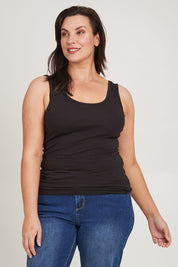 Model Poppy wearing size 16 of the Emma Cotton Scoop Tank in colour Black (Black), from the front, cropped image