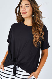 Model Madeline wearing size 10 of the Katie Knot Tee in colour Black (Black), from the front, cropped image