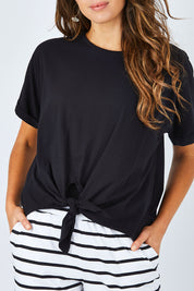 Model Madeline wearing size 10 of the Katie Knot Tee in colour Black (Black), from the front, cropped image