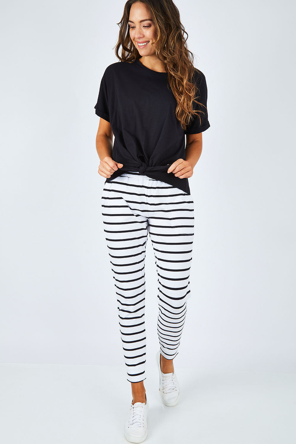 Model Madeline wearing size 10 of the Katie Knot Tee in colour Black (Black), from the front, showing the whole outfit