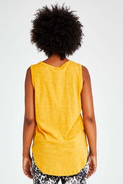 Model Olivia wearing size 10 of the Keira Tank in colour Mustard, from the back