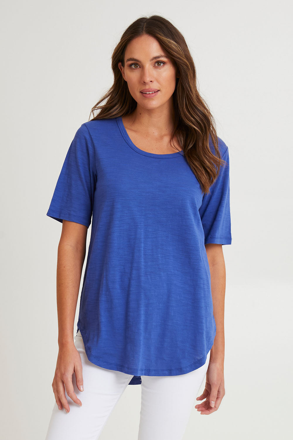 Model Madeline wearing size 10 of the Ariana Cotton Tee in colour Oceanblue (Blue), from the front, cropped image