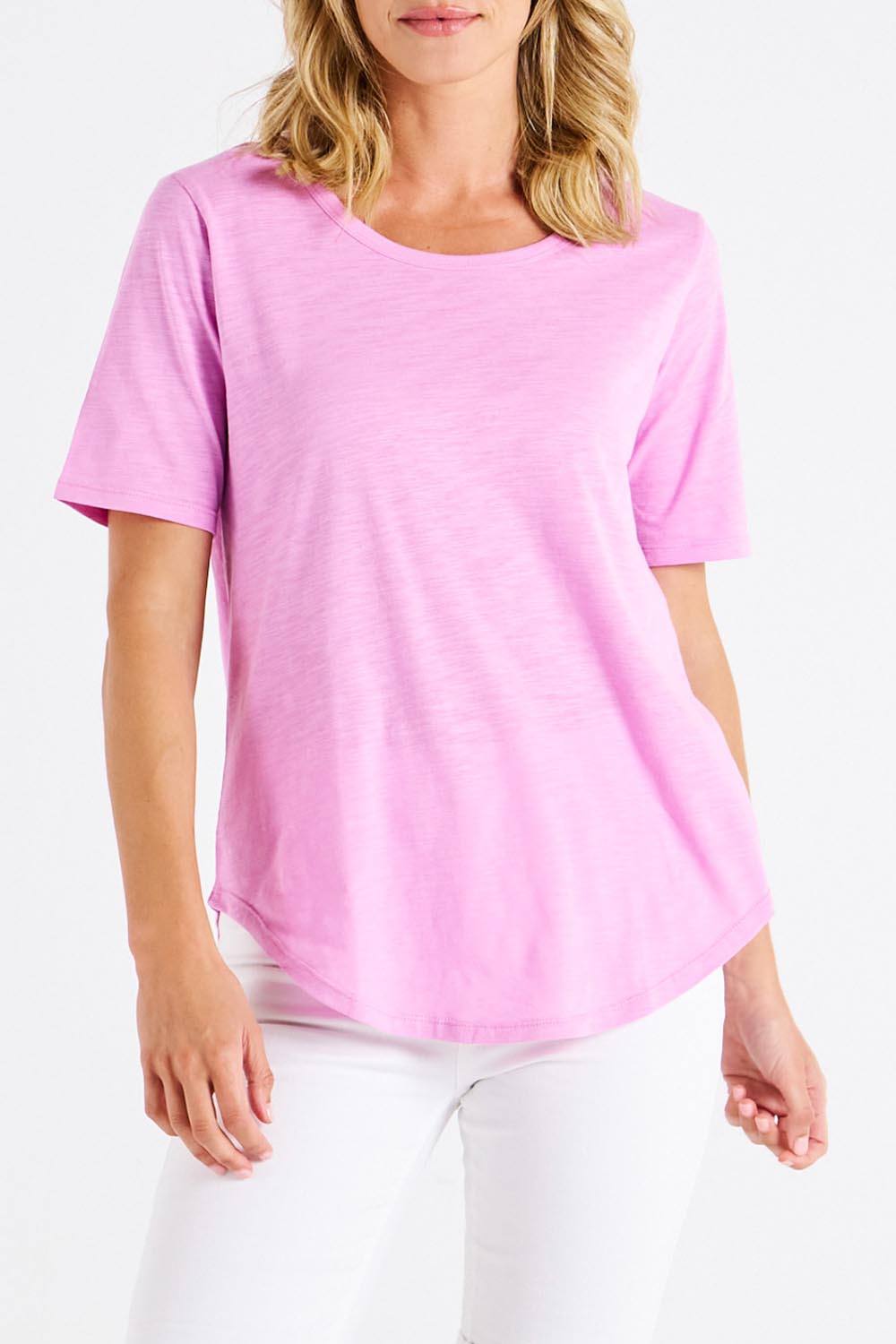 A model wearing the Ariana Cotton Tee in colour Vividberry (Pink), from the front, cropped image