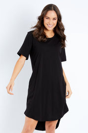 Model Pamela wearing size 10 of the Nyree Dress in colour Black (Black), from the front, cropped image