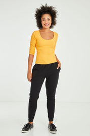 Model Olivia wearing size 10 of the Heidi Pant in colour Black (Black), from the front, showing the whole outfit