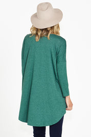 A model wearing the Celeste Tunic Tee in colour Greenmarle (Green), from the back