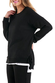 A model wearing the Kiki Sweat in colour Black (Black), from the front, cropped image