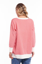 A model wearing the Gianna Sweater in colour Heart (Red), from the back