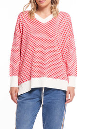 A model wearing the Gianna Sweater in colour Heart (Red), from the front, cropped image