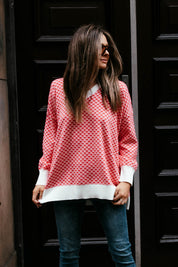 A model wearing the Gianna Sweater in colour Heart (Red), from the front, showing the whole outfit