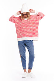 A model wearing the Gianna Sweater in colour Heart (Red), from the front, showing the whole outfit