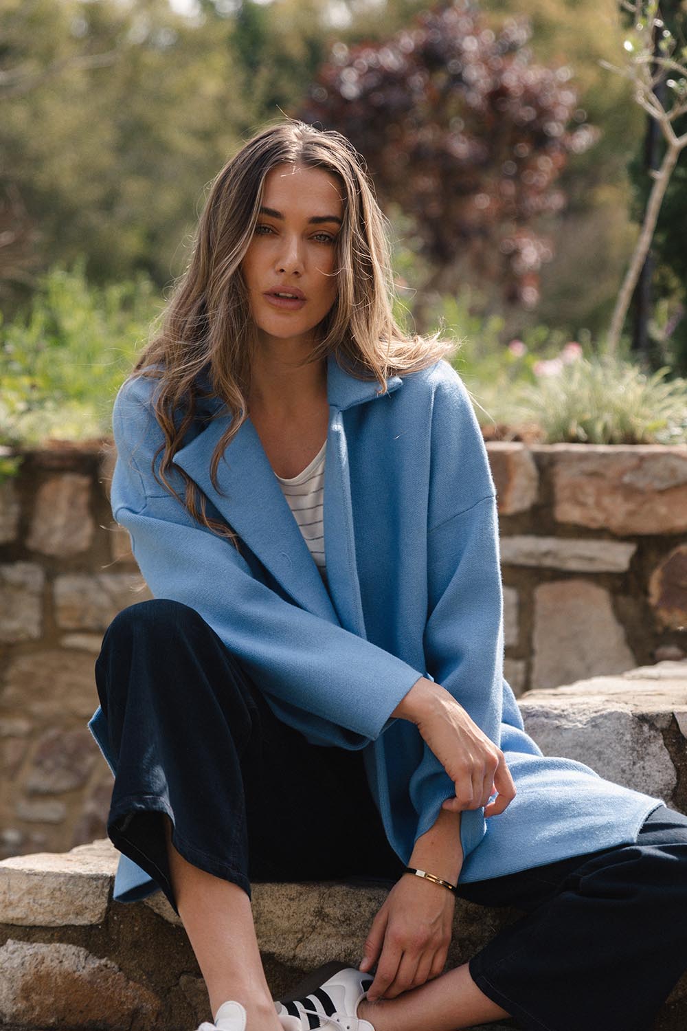 A model wearing the Bristol Coatigan in colour Blue (Blue), from the front, showing the whole outfit