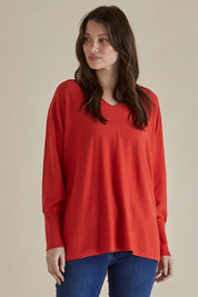 A model wearing the Destiny Knit Jumper in colour Flame (Red), from the front, cropped image