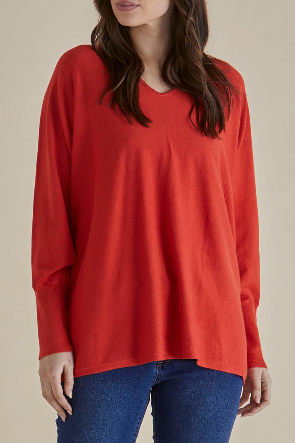 A model wearing the Destiny Knit Jumper in colour Flame (Red), from the front, cropped image