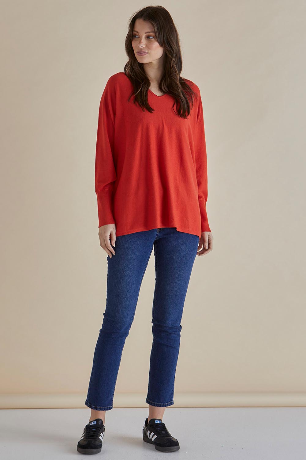 A model wearing the Destiny Knit Jumper in colour Flame (Red), from the front, showing the whole outfit