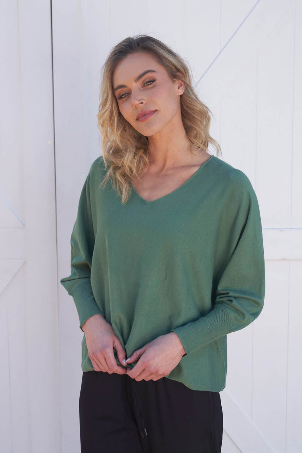 A model wearing the Destiny Knit Jumper in colour Powdergree (Green), from the front, showing the whole outfit