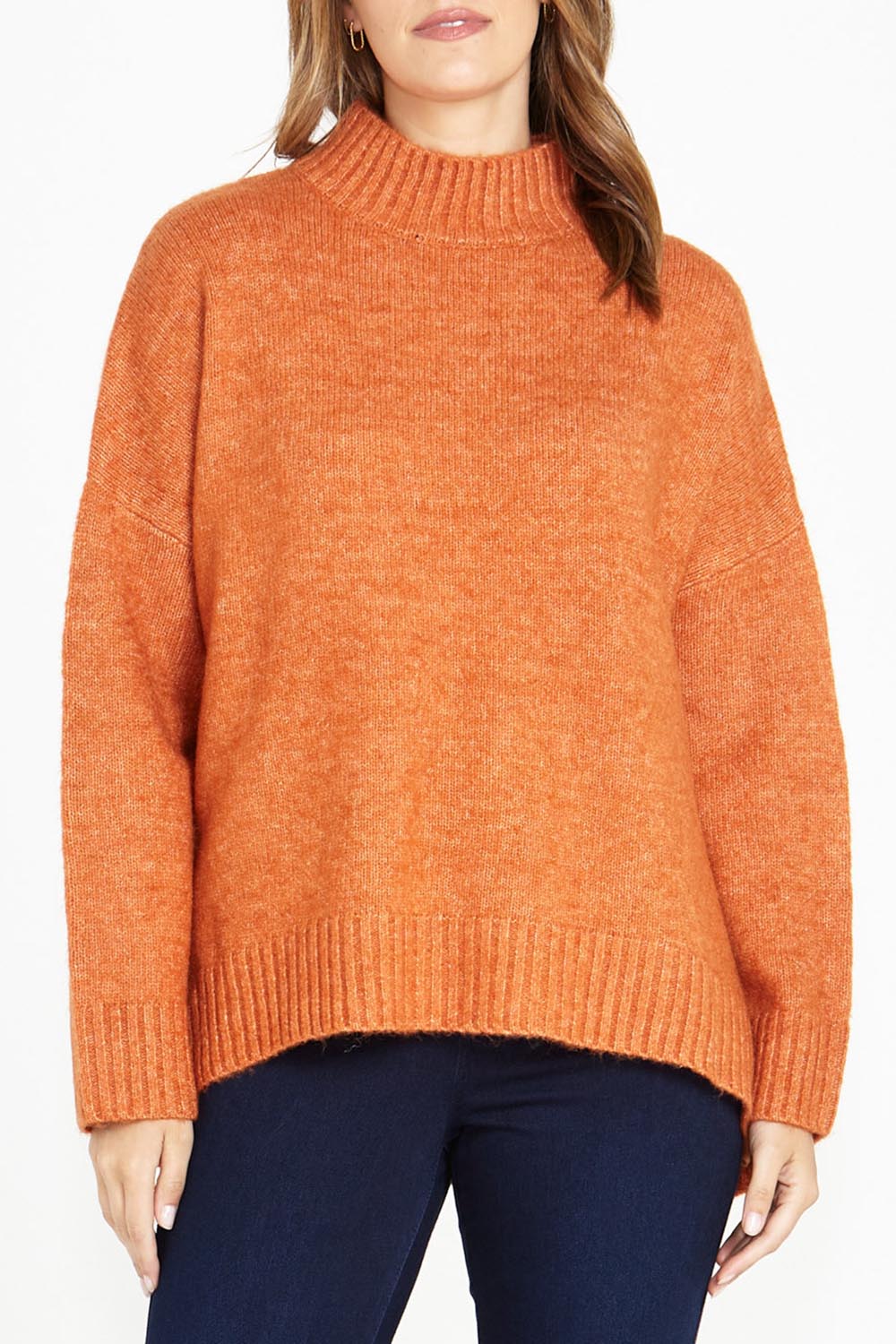 A model wearing the Luna Knit Jumper in colour Amber, from the front, cropped image