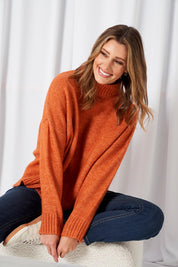 A model wearing the Luna Knit Jumper in colour Amber, from the front, showing the whole outfit