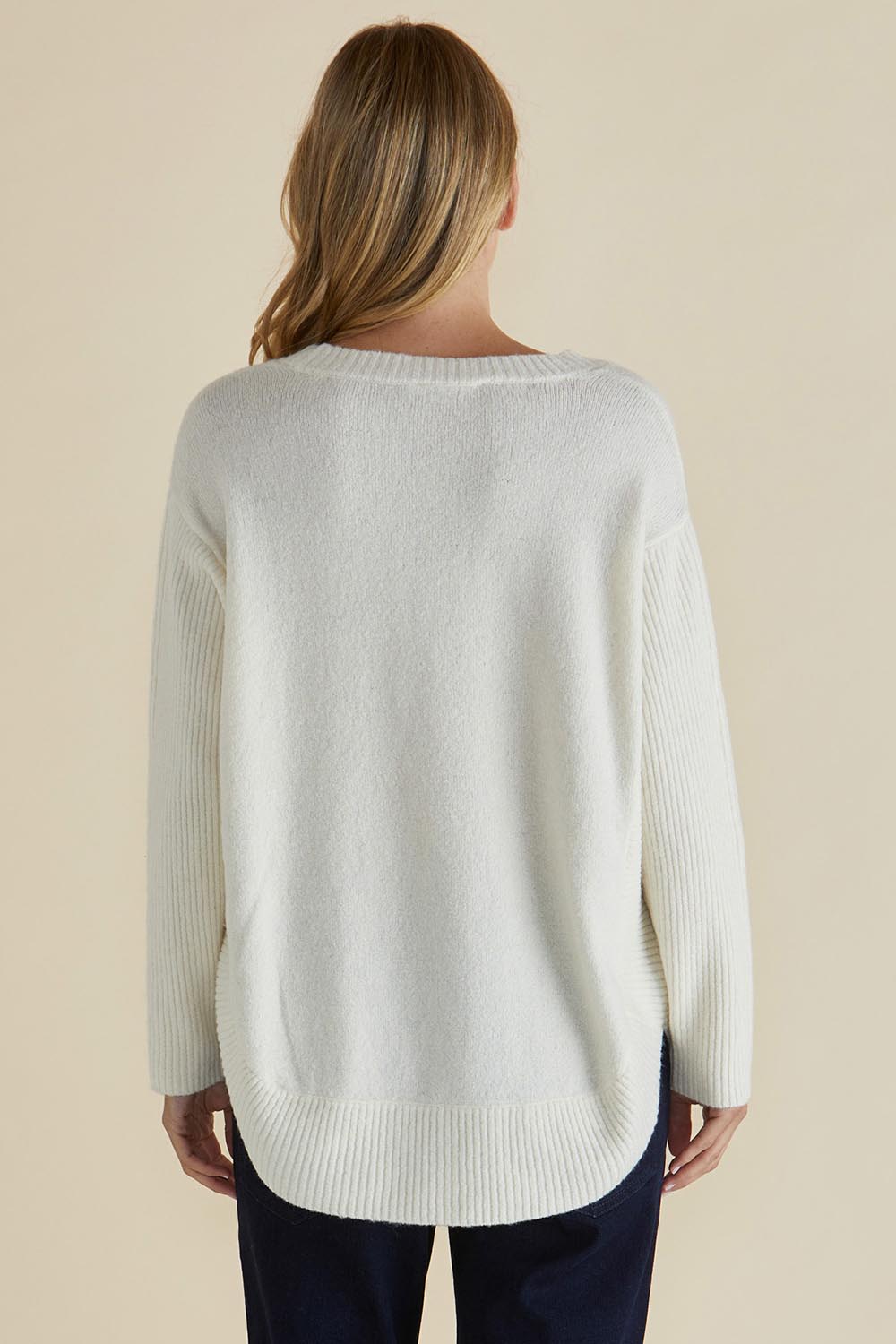 A model wearing the Soho Knit Sweater in colour Oat, from the back