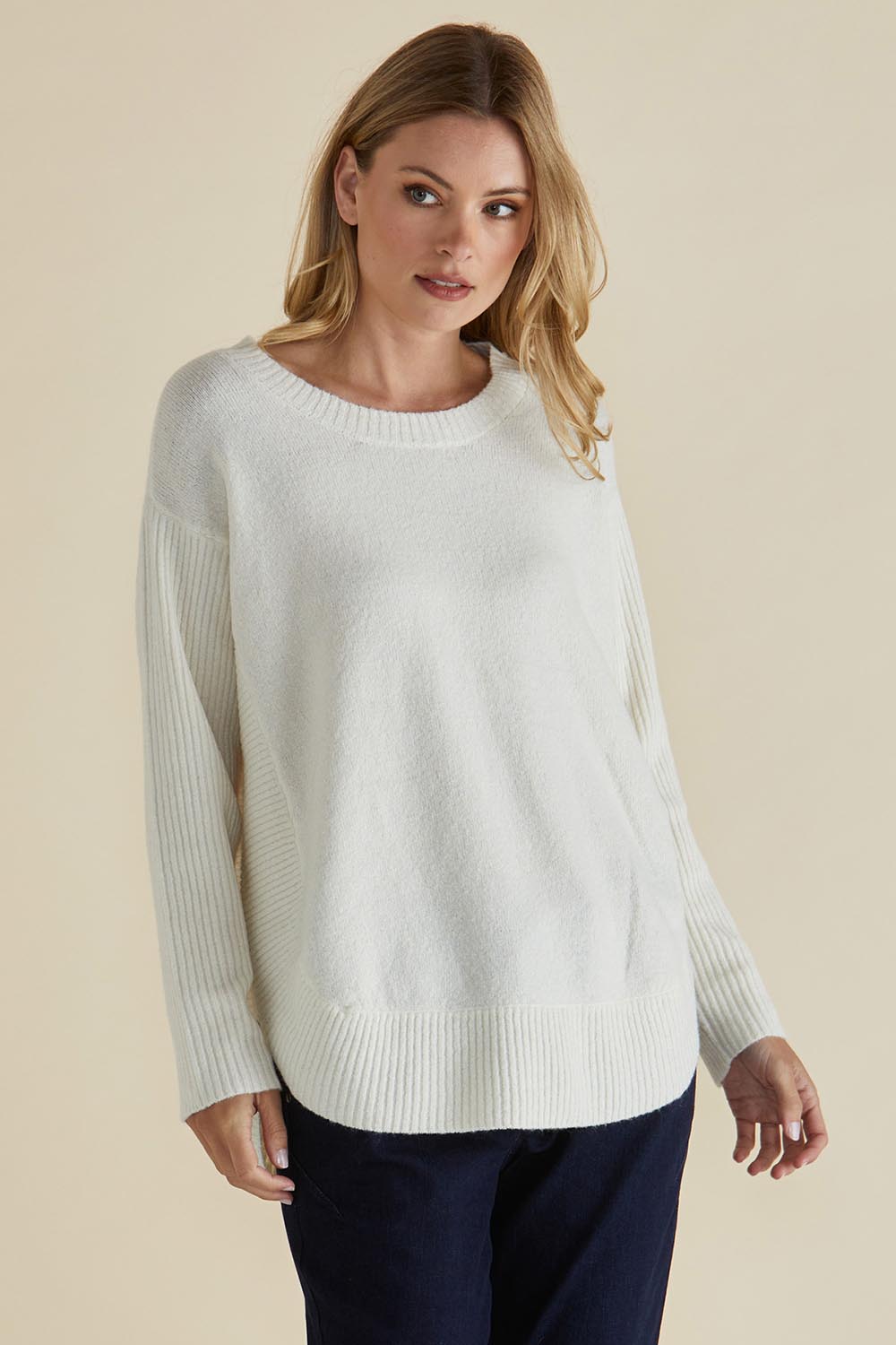 A model wearing the Soho Knit Sweater in colour Oat, from the front, cropped image