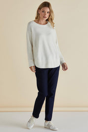 A model wearing the Soho Knit Sweater in colour Oat, from the front, showing the whole outfit