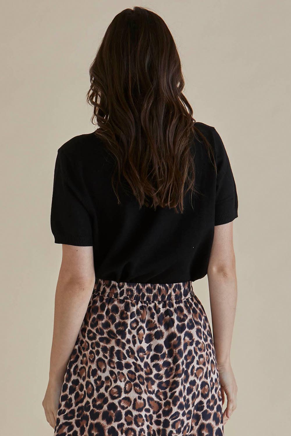 A model wearing the Robbie Knit Tee in colour Black (Black), from the back