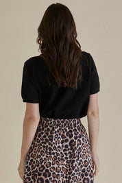 A model wearing the Robbie Knit Tee in colour Black (Black), from the back