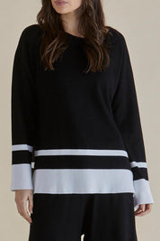 A model wearing the Eleanor Knit Jumper in colour Black (Black), from the front, cropped image
