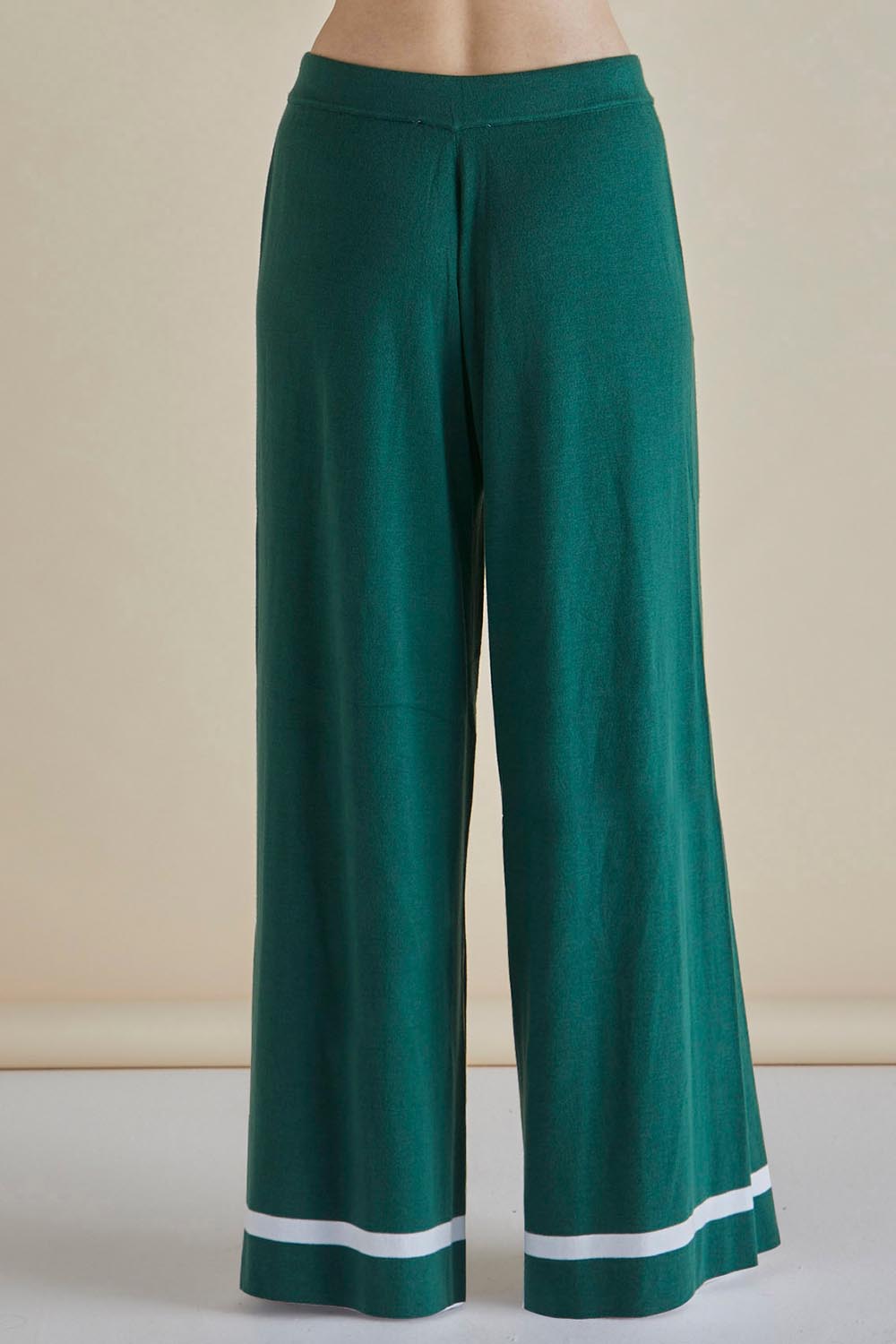 A model wearing the Delphine Knit Pant in colour Basil (Green), from the back