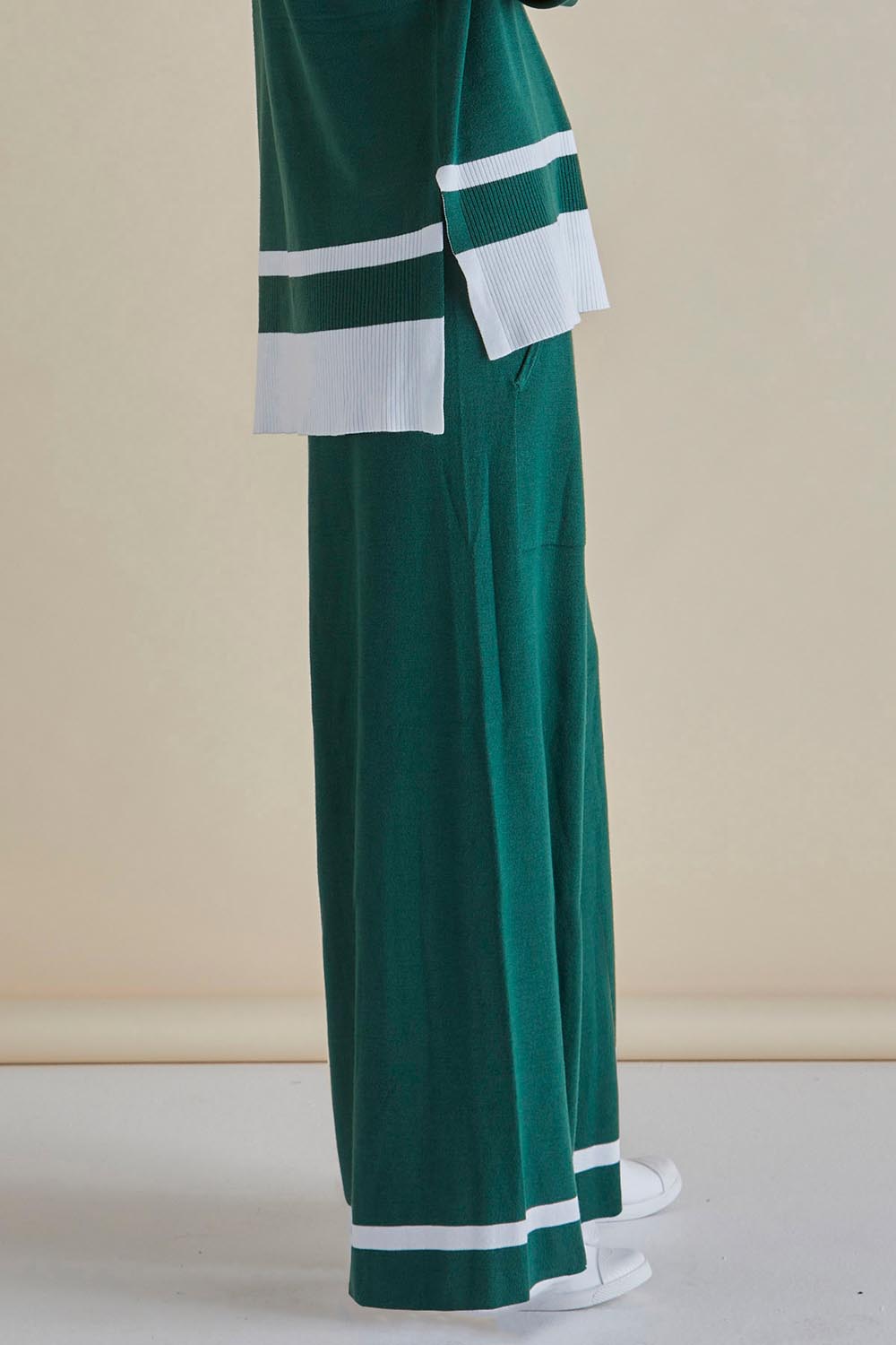 A model wearing the Delphine Knit Pant in colour Basil (Green), from the front, cropped image