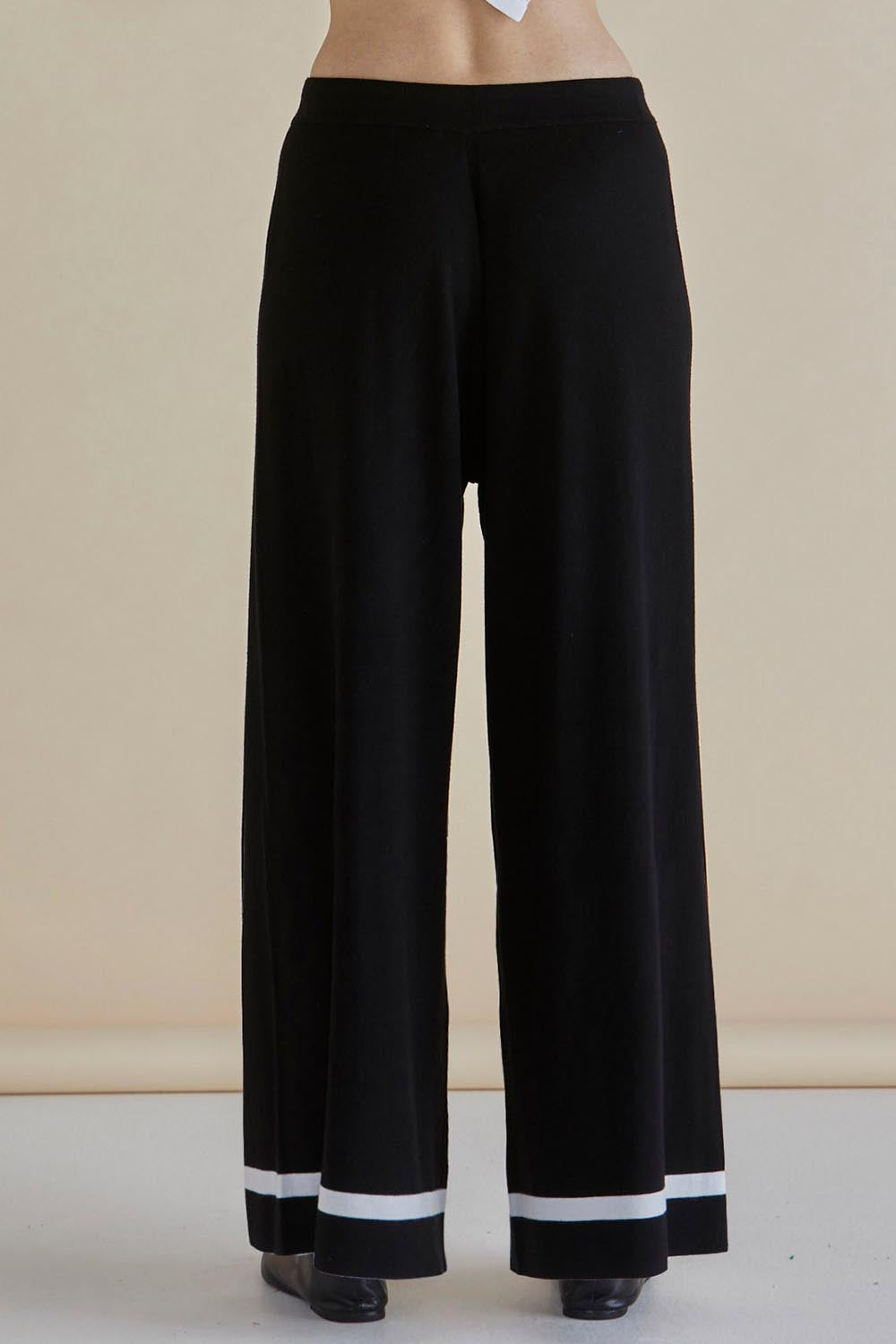 A model wearing the Delphine Knit Pant in colour Black (Black), from the back