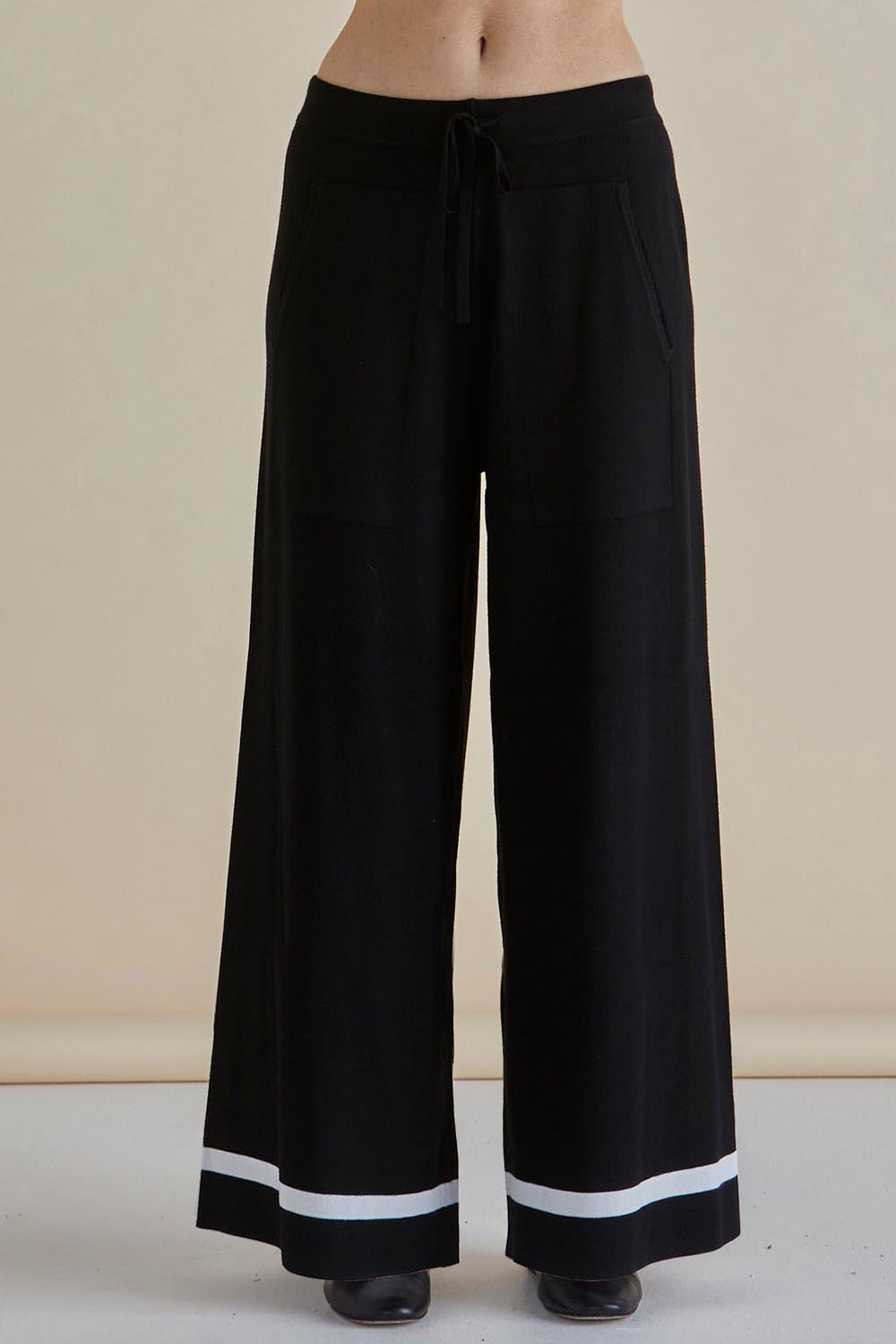 A model wearing the Delphine Knit Pant in colour Black (Black), from the front, cropped image