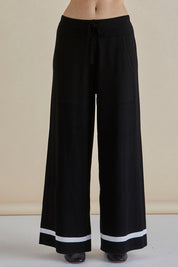 A model wearing the Delphine Knit Pant in colour Black (Black), from the front, cropped image