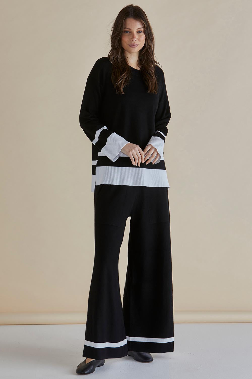 A model wearing the Delphine Knit Pant in colour Black (Black), from the front, showing the whole outfit