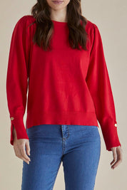 A model wearing the Colette Sweater in colour Red (Red), from the front, cropped image
