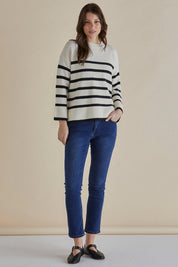 A model wearing the Edith Knit Jumper in colour Blkstripe (White), from the front, showing the whole outfit