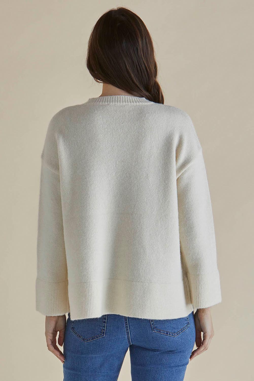 A model wearing the Edith Knit Jumper in colour Cream (White), from the back