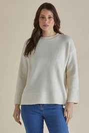 A model wearing the Edith Knit Jumper in colour Cream (White), from the front, cropped image