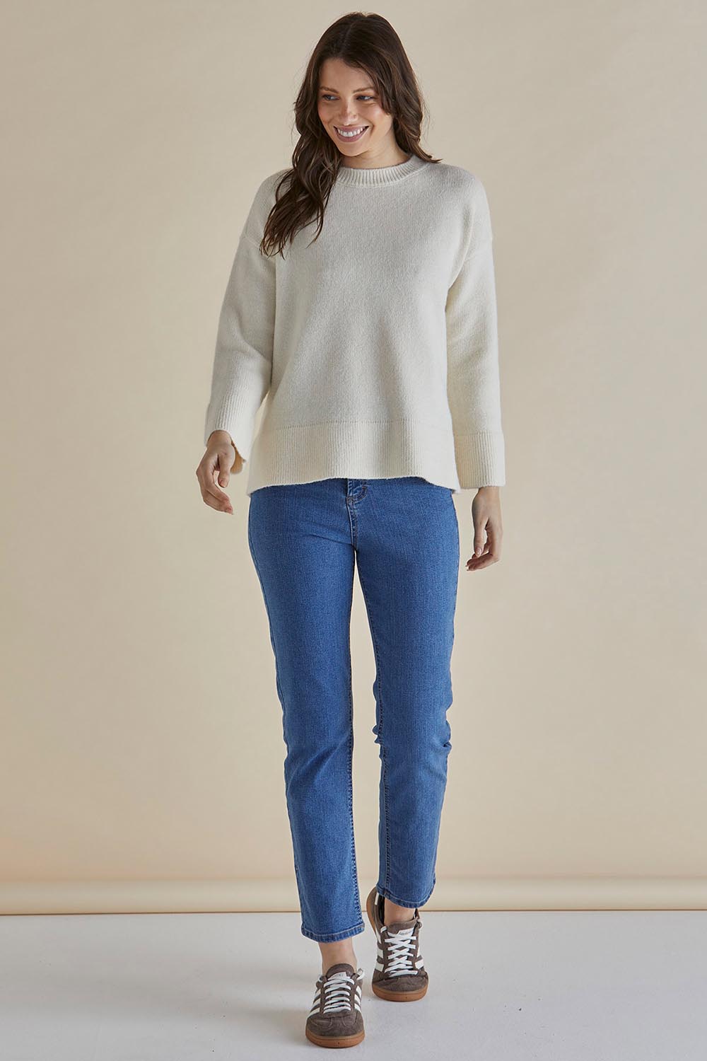 A model wearing the Edith Knit Jumper in colour Cream (White), from the front, showing the whole outfit