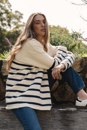 A model wearing the Emy Cardigan in colour Bluestripe (Blue), from the front, showing the whole outfit