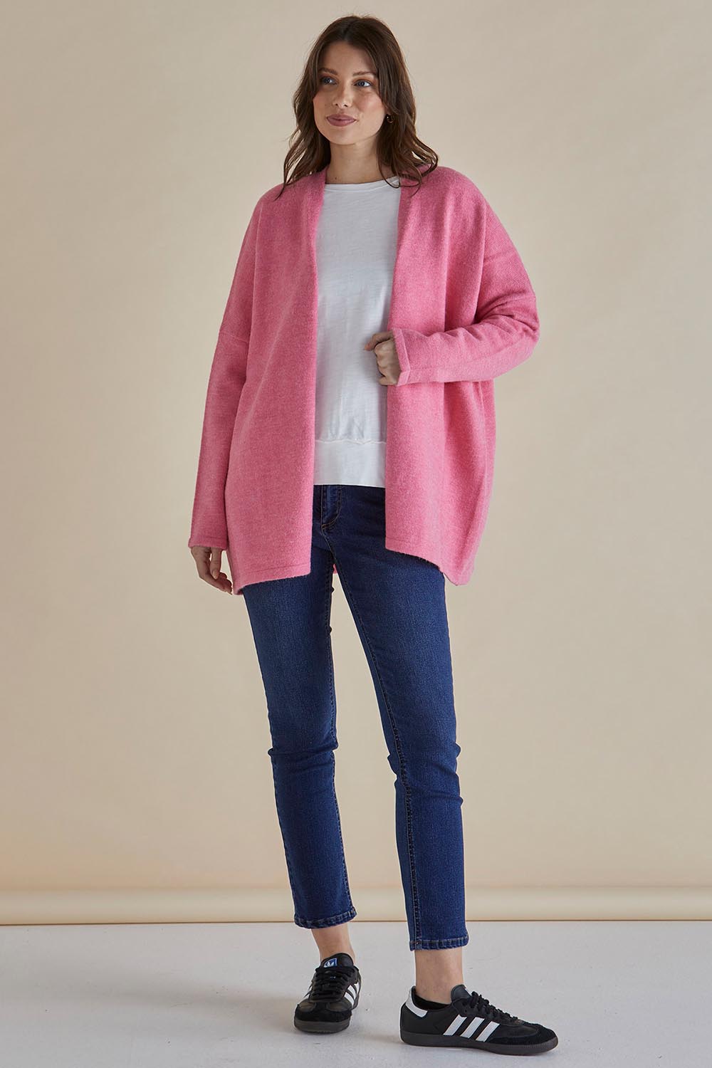 A model wearing the Emy Cardigan in colour Peonypink (Pink), from the front, showing the whole outfit