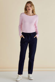 A model wearing the Cable Mini Jumper in colour Babypink (Pink), from the front, showing the whole outfit